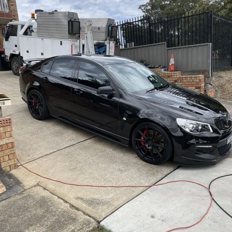 Black Commodore after a full detail, washed and dried on a driveway